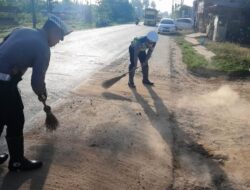 Peduli Keselamatan Pengendara, Anggota Satlantas Polres Aceh Timur Bersihkan Material Kerikil di Jalan