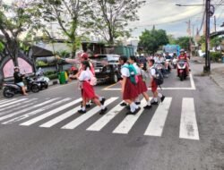 Pastikan Kelancaran Arus Lalulintas, Anggota Lantas Polres Karangasem Bantu Seberangkan Siswa Siswi SD N 4 Subagan