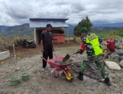 Babinsa Sertu Raswan Juandi Bantu Warga Cor Jalan Menuju Kantor Desa di Atu Lintang