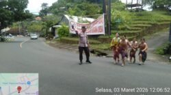 Cegah Laka Lantas, Bhabinkamtibmas Desa Bugbug Sebrangkan Para Pelajar