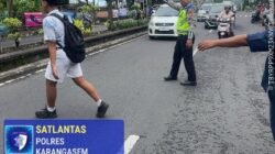 Cegah Lakalantas, Anggota Lantas Polres Karangasem Bantu Seberangkan Siswa Siswi SMP N 2 Amlapura