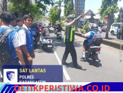 Cegah Lakalantas Kalangan Pelajar,  Personel Sat Lantas Bantu Sebrangkan Siswa-siswi SMP Negeri 2 Amlapura saat Sepulang Sekolah 