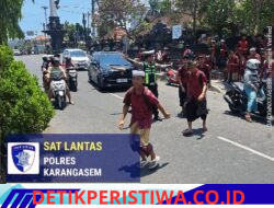 Atensi Bubaran Sekolah, Personel Lalulintas Bantu Sebrangkan Siswa-siswi SMPN 2 Amlapura